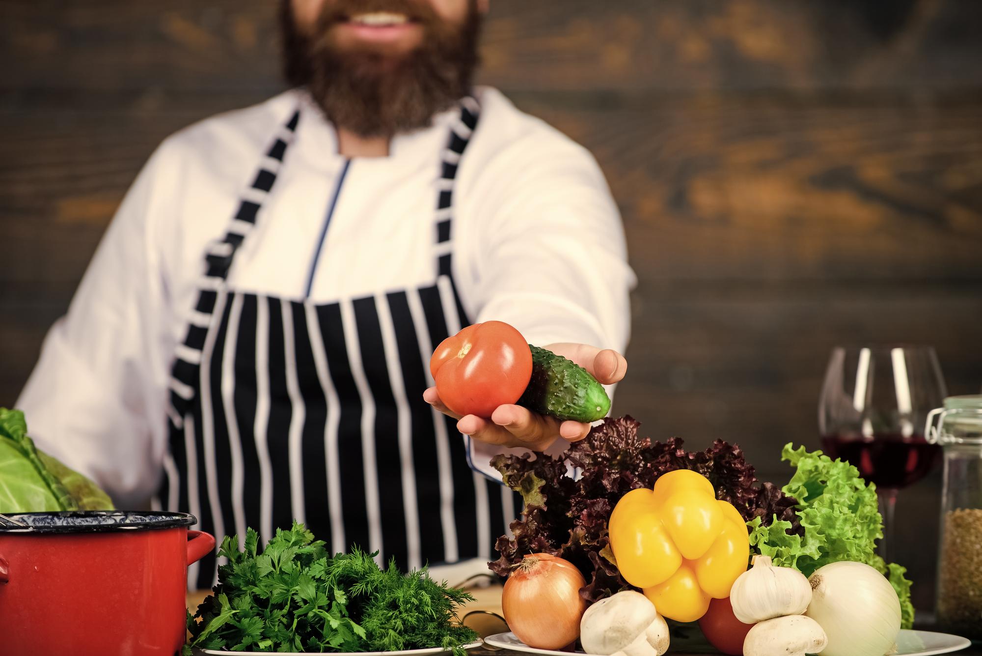 Chef arranging seasonal ingredients in kitchen